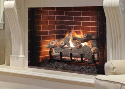 A fireplace with brick and stone surround in living room.