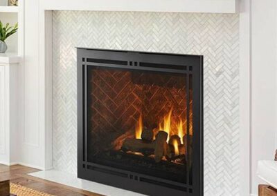 A fireplace with white tile and wood floors.